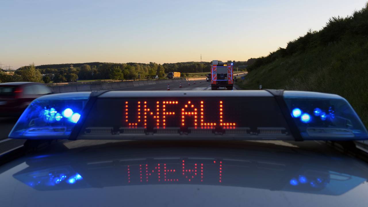 Ein Polizeifahrzeug warnt auf der Autobahn mit eine Leuchtschrift vor einer Unfallstelle.