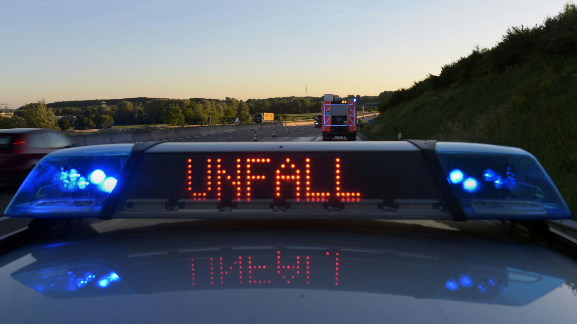 Ein Polizeifahrzeug warnt auf der Autobahn mit eine Leuchtschrift vor einer Unfallstelle.