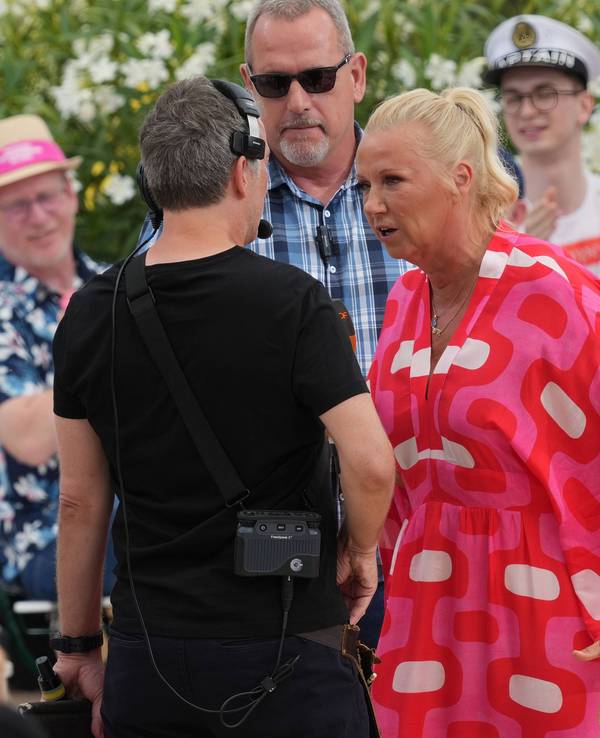 Moderatorin Andrea Kiewel spricht im ZDF-„Fernsehgarten“ mit einem Produktionsmitarbeiter.