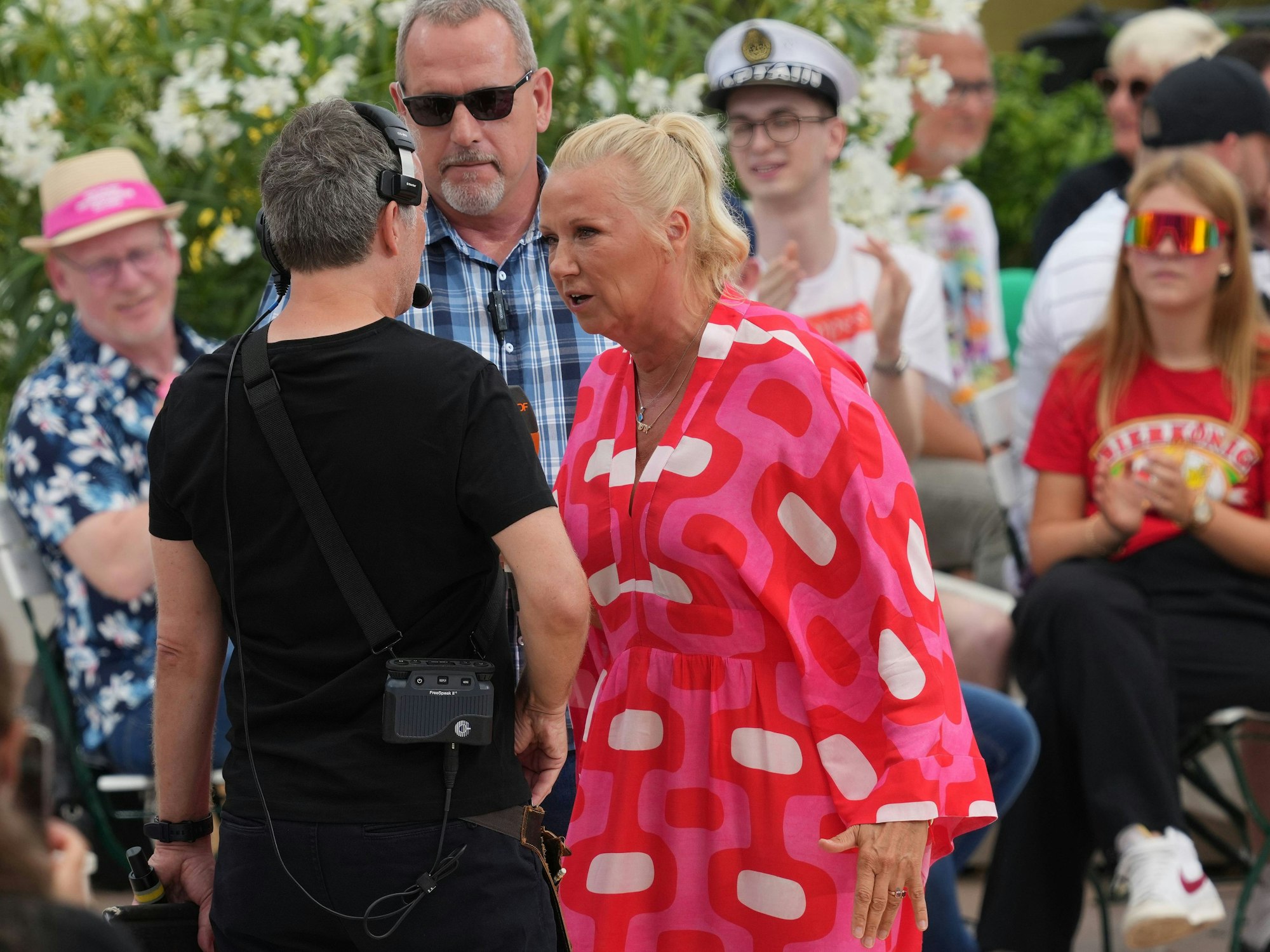 Moderatorin Andrea Kiewel spricht im ZDF-„Fernsehgarten“ mit einem Produktionsmitarbeiter.