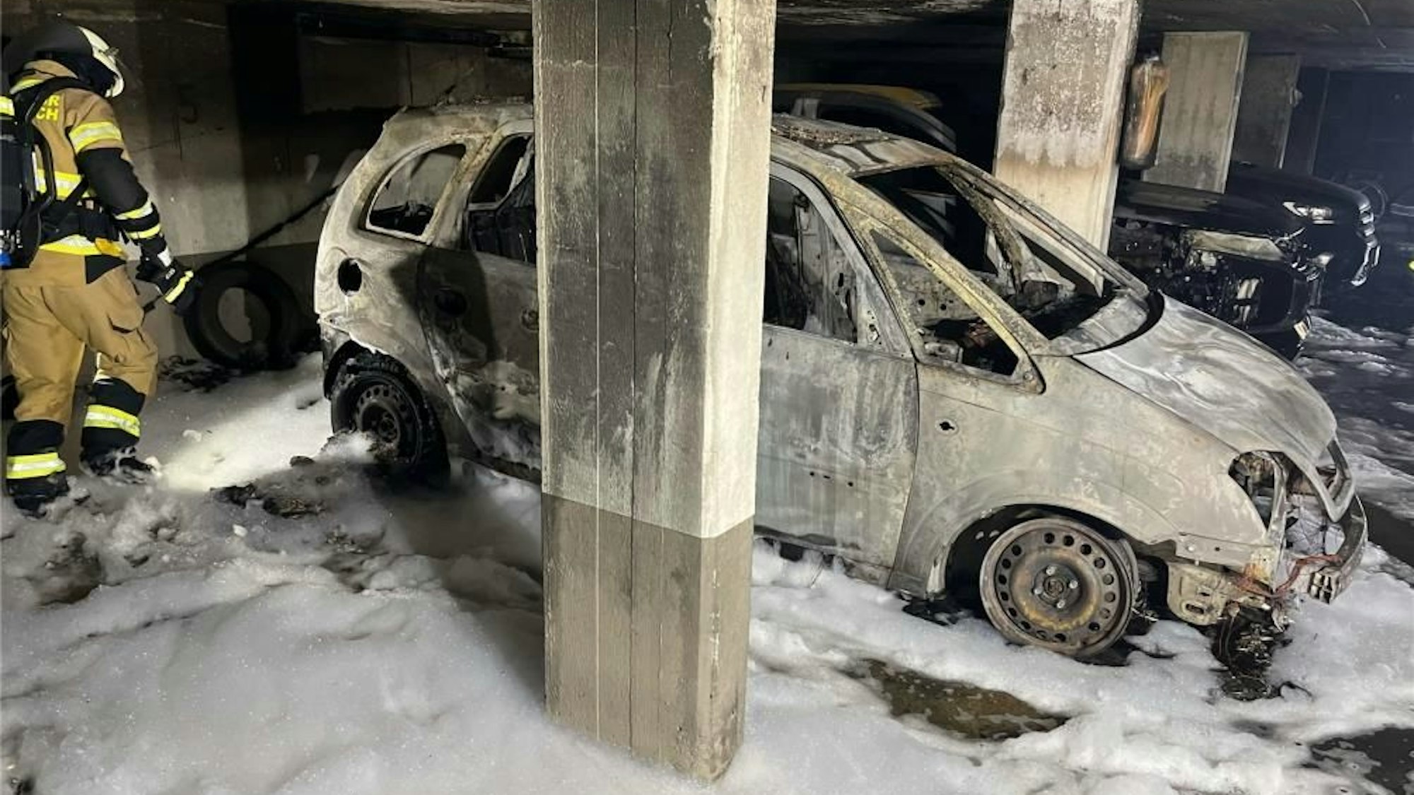 Ein ausgebranntes Auto in einer Tiefgarage.
