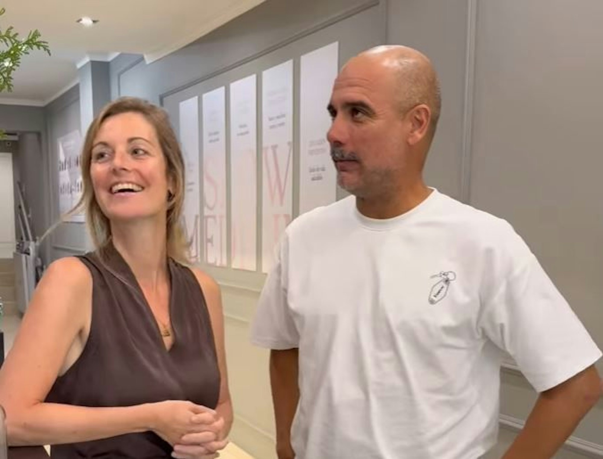 Pep Guardiola (mit Schnauzbart) spricht in einer Klinik mit einer Frau.