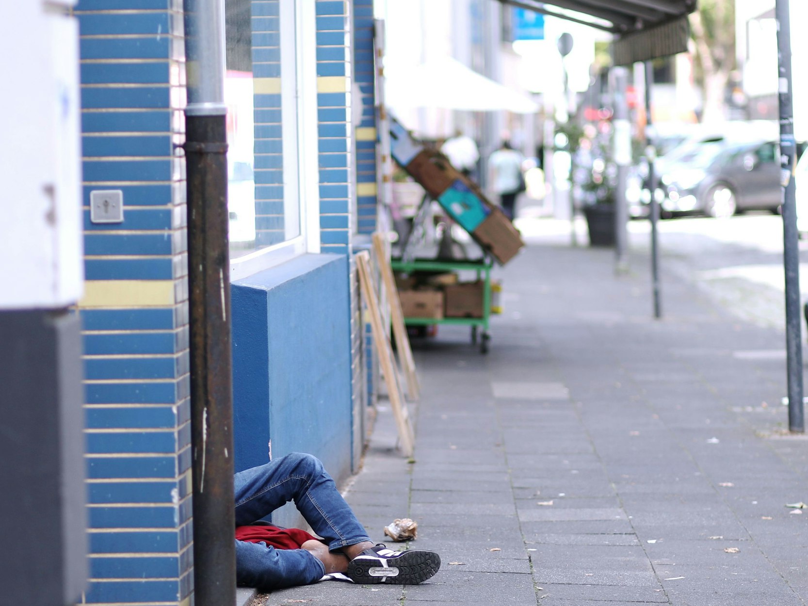 Ein Junkie schläft sein Rausch vor dem Eingang eines Mehrfamilienhauses an der Thieboldsgasse aus.