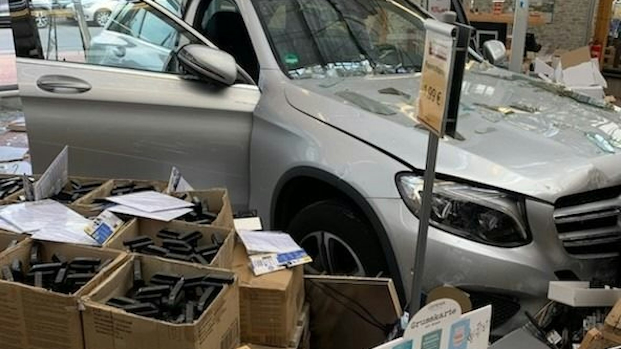 Ein Auto steckt in der Glasfront eines Geschäfts.