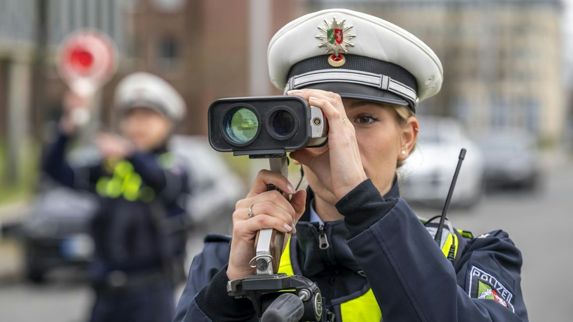 Ein Polizist führt eine Geschwindigkeitsmessung durch.