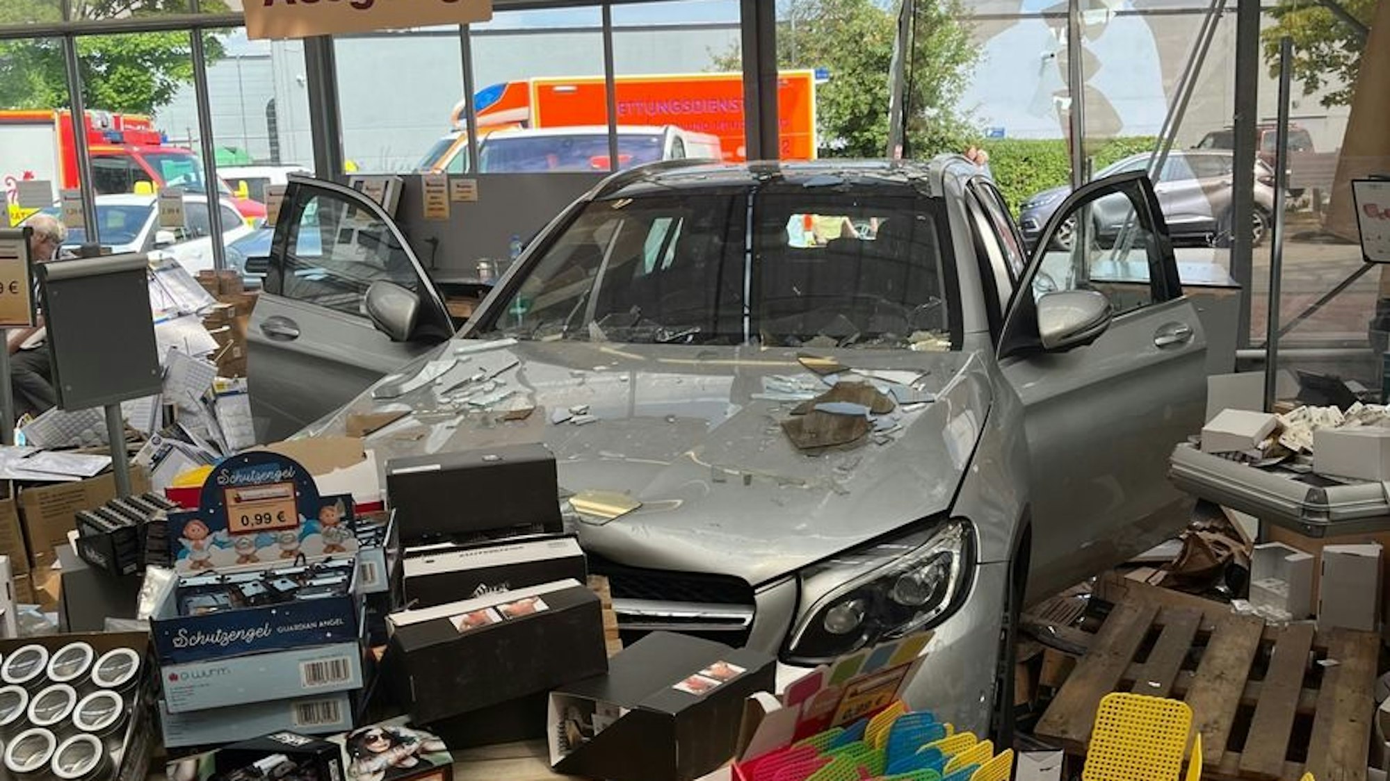 Ein Mercedes steht in der zerstörten Glasfront eines Geschäfts in Ratingen.