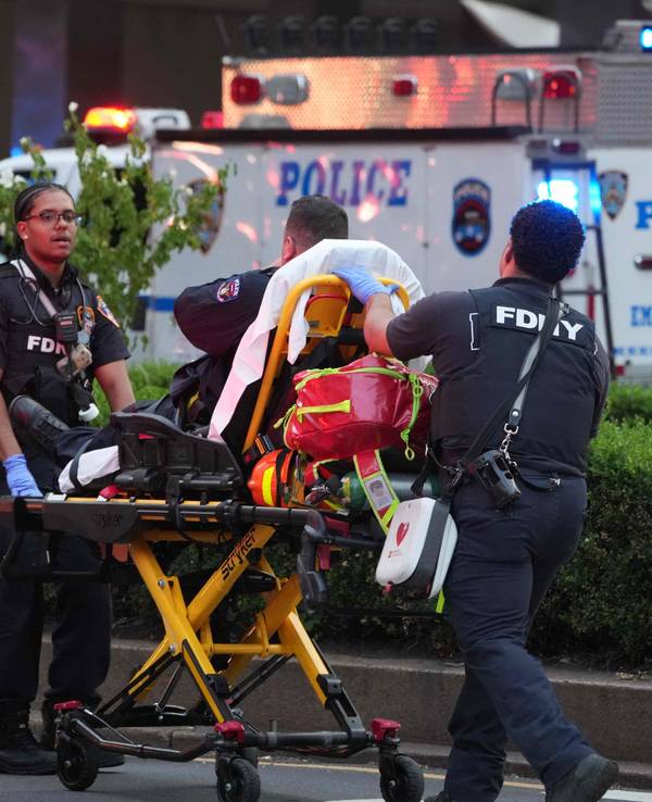 Feuerwehrleute kümmern sich nach dem Angriff um einen verletzten Polizisten.