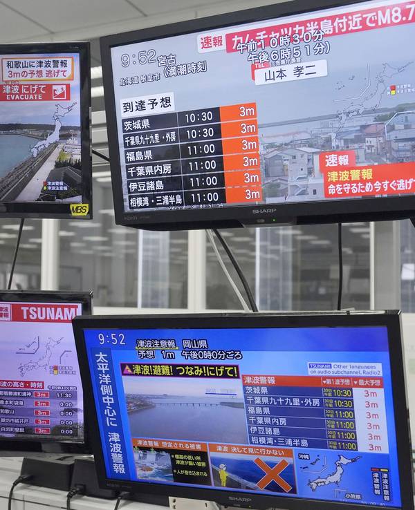 Nachdem ein starkes Erdbeben im Fernen Osten Russlands eine Tsunami-Warnung für Teile Japans ausgelöst hat, zeigen Fernsehbildschirme in Osaka Nachrichten.