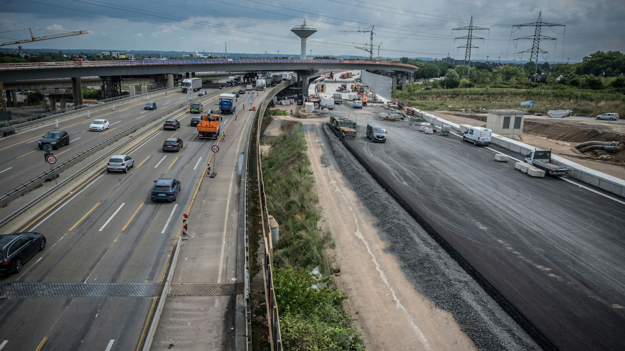 An einer Autobahn, auf der wenige Fahrzeuge unterwegs sind, wird linker Hand eine neue Fahrspur gebaut.