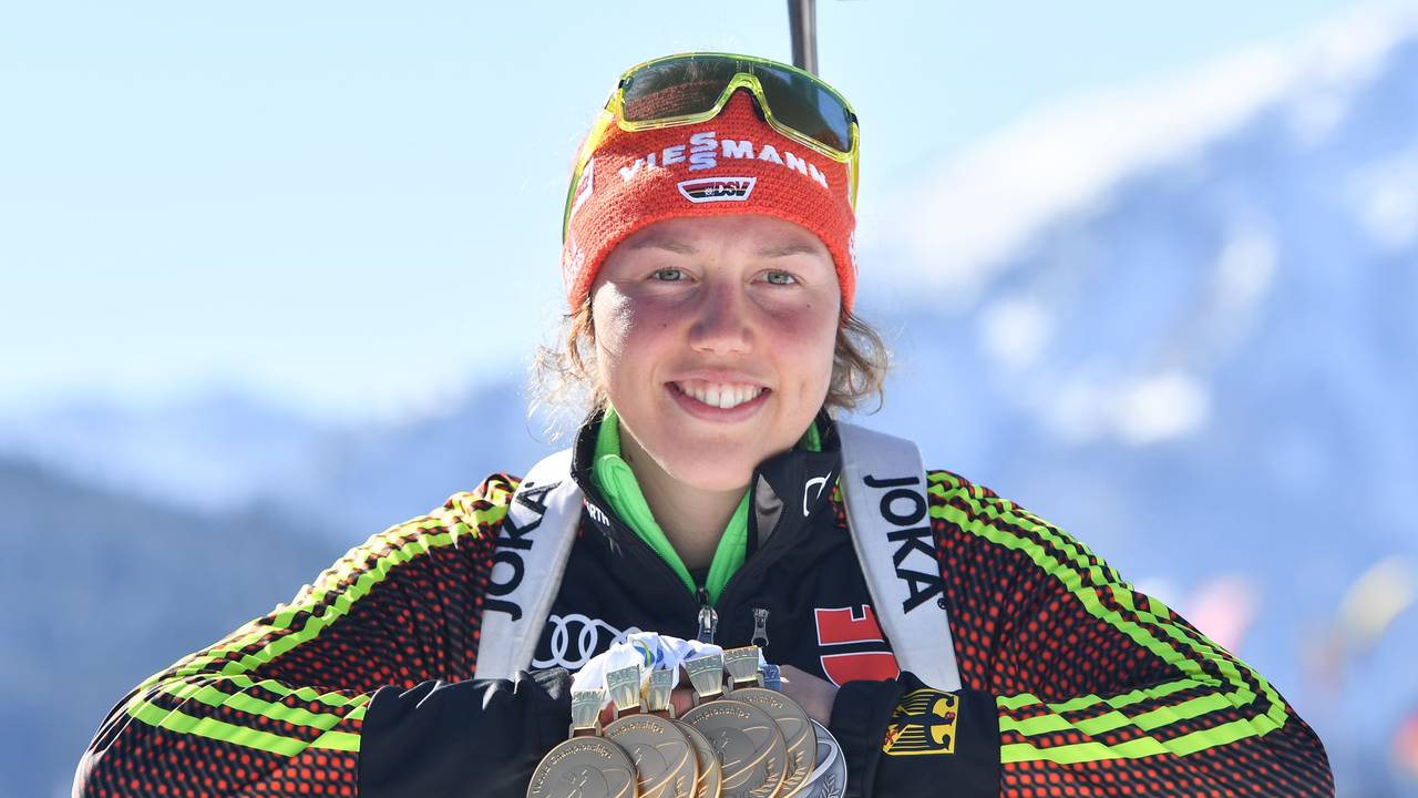 Laura Dahlmeiers lächelt mit ihren WM-Medaillen um den Hals in die Kamera.