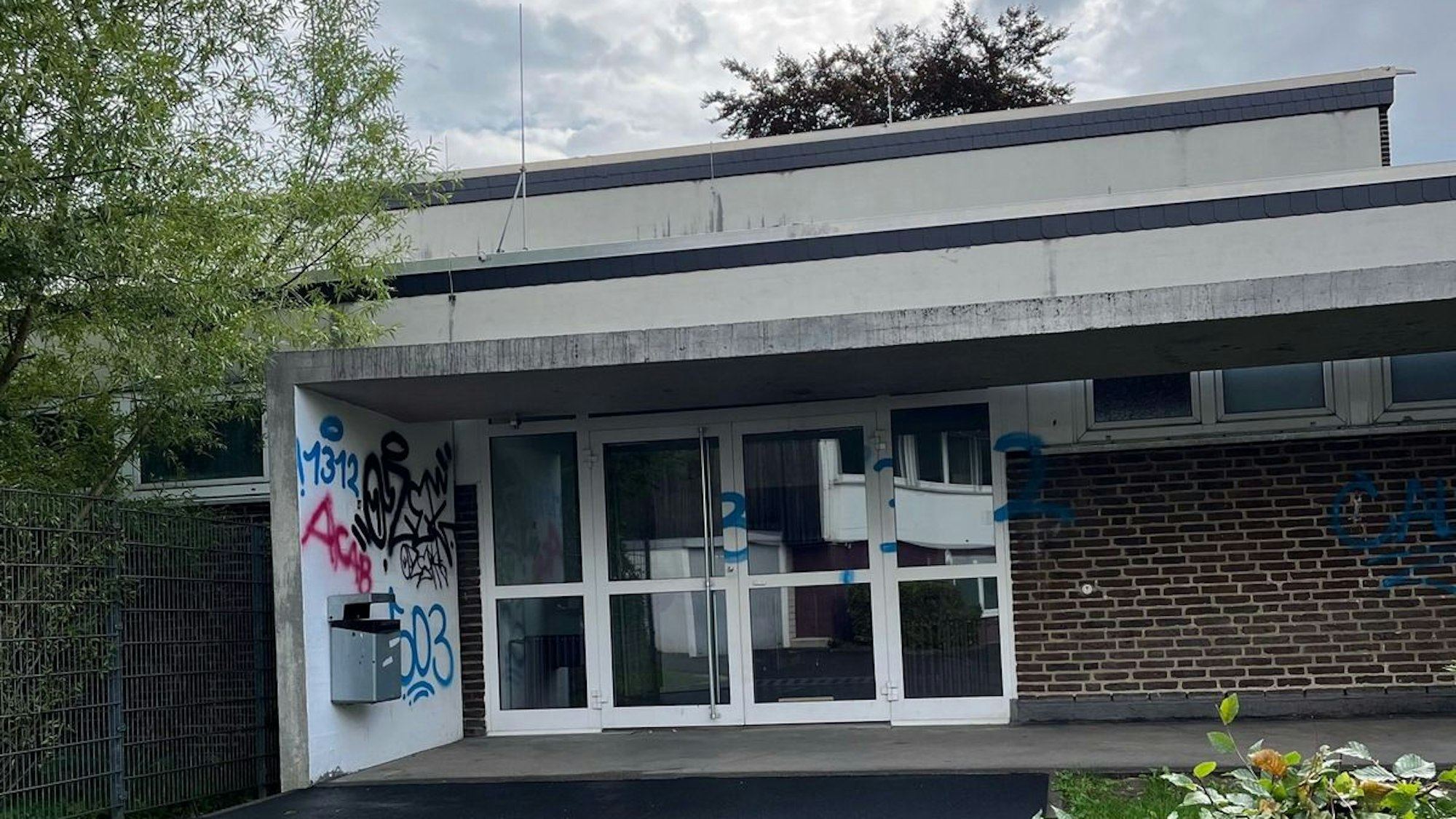Ein Graffiti an der Wand eines Schulgebäudes.