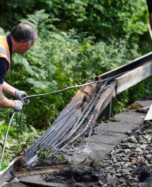 Mitarbeiter der Deutschen Bahn arbeiten an einem Gleisabschnitt in Düsseldorf. Dort wurde neben der Bahnstrecke Feuer in einem Kabeltunnel gelegt, der sechs Kabel in Mitleidenschaft zog.