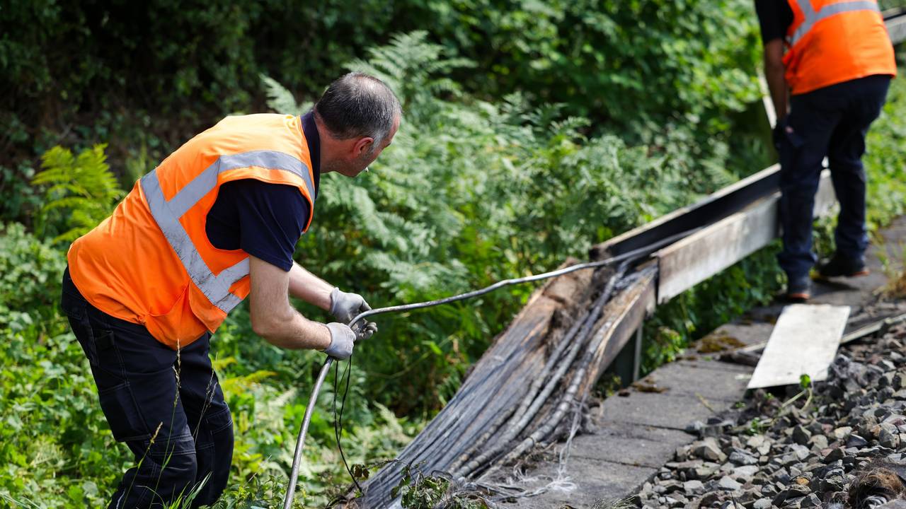 Mitarbeiter der Deutschen Bahn arbeiten an einem Gleisabschnitt in Düsseldorf. Dort wurde neben der Bahnstrecke Feuer in einem Kabeltunnel gelegt, der sechs Kabel in Mitleidenschaft zog.