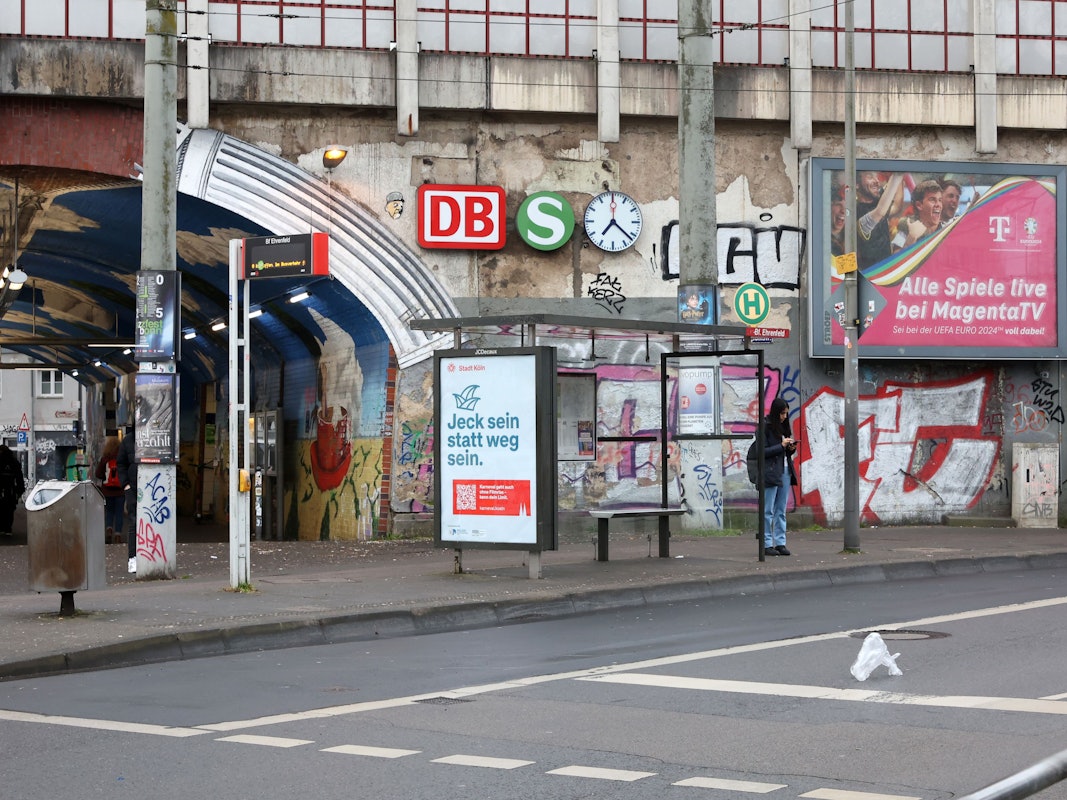 An einer Bahnunterführungen, die vollgeschmiert ist mit Graffiti, hängen Schilder.