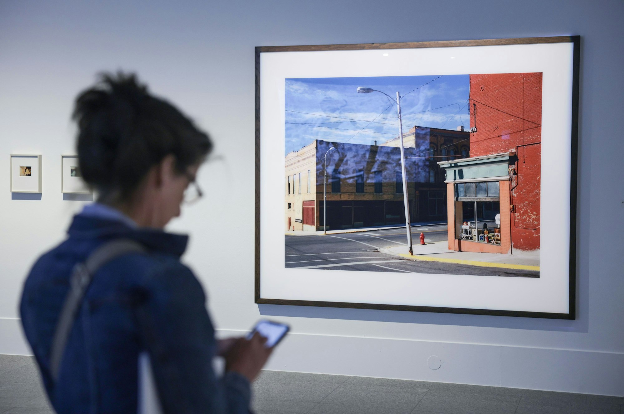 Eine Frau steht vor einer Fotografie von Wim Wenders aus Montana, USA.
