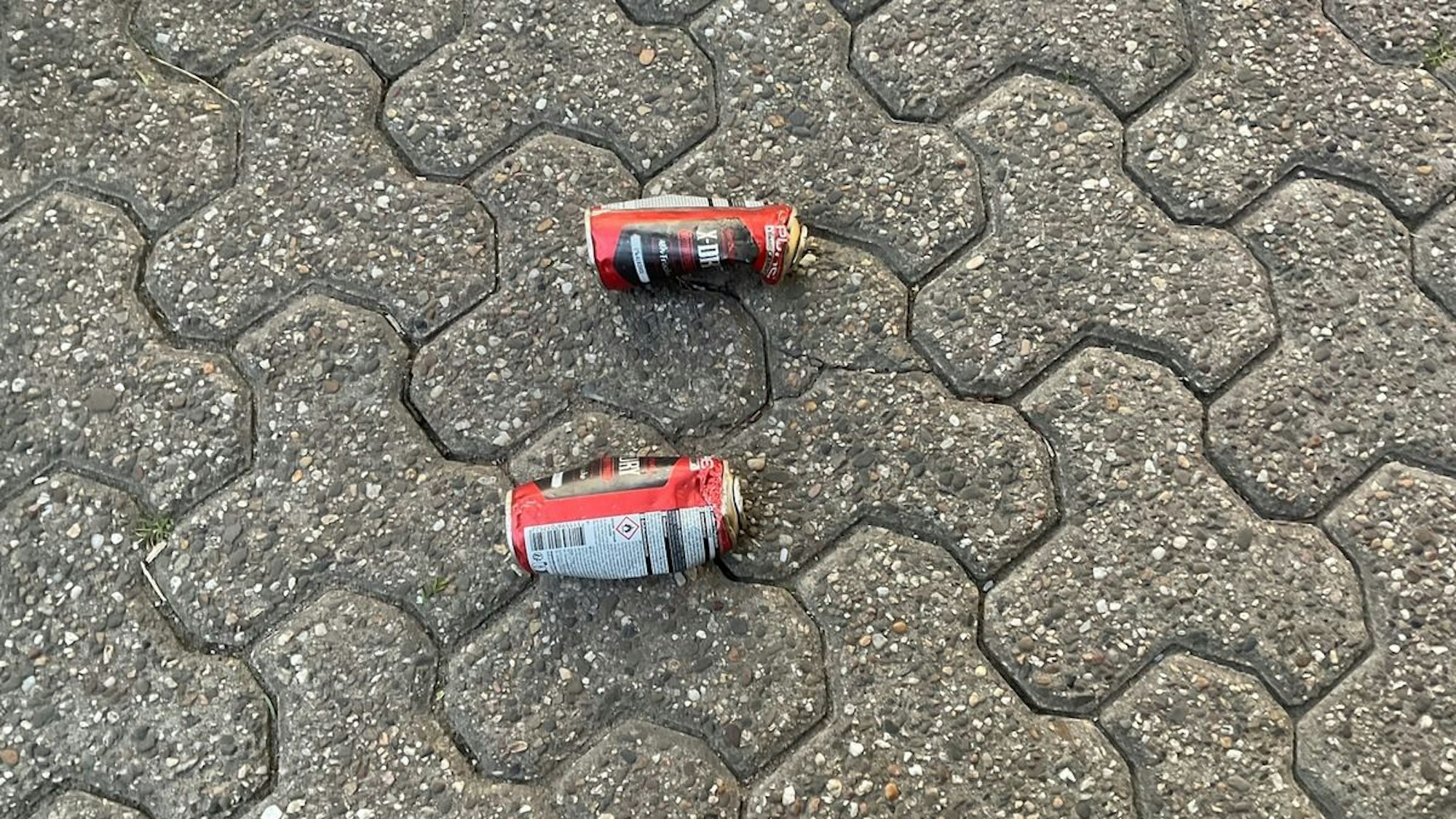 Zwei ausgebrannte Spraydosen liegen auf dem Boden.