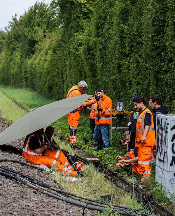 Mitarbeiter der Deutschen Bahn reparieren Kabel an der Stelle, wo der zweite Brandanschlag festgestellt wurde.