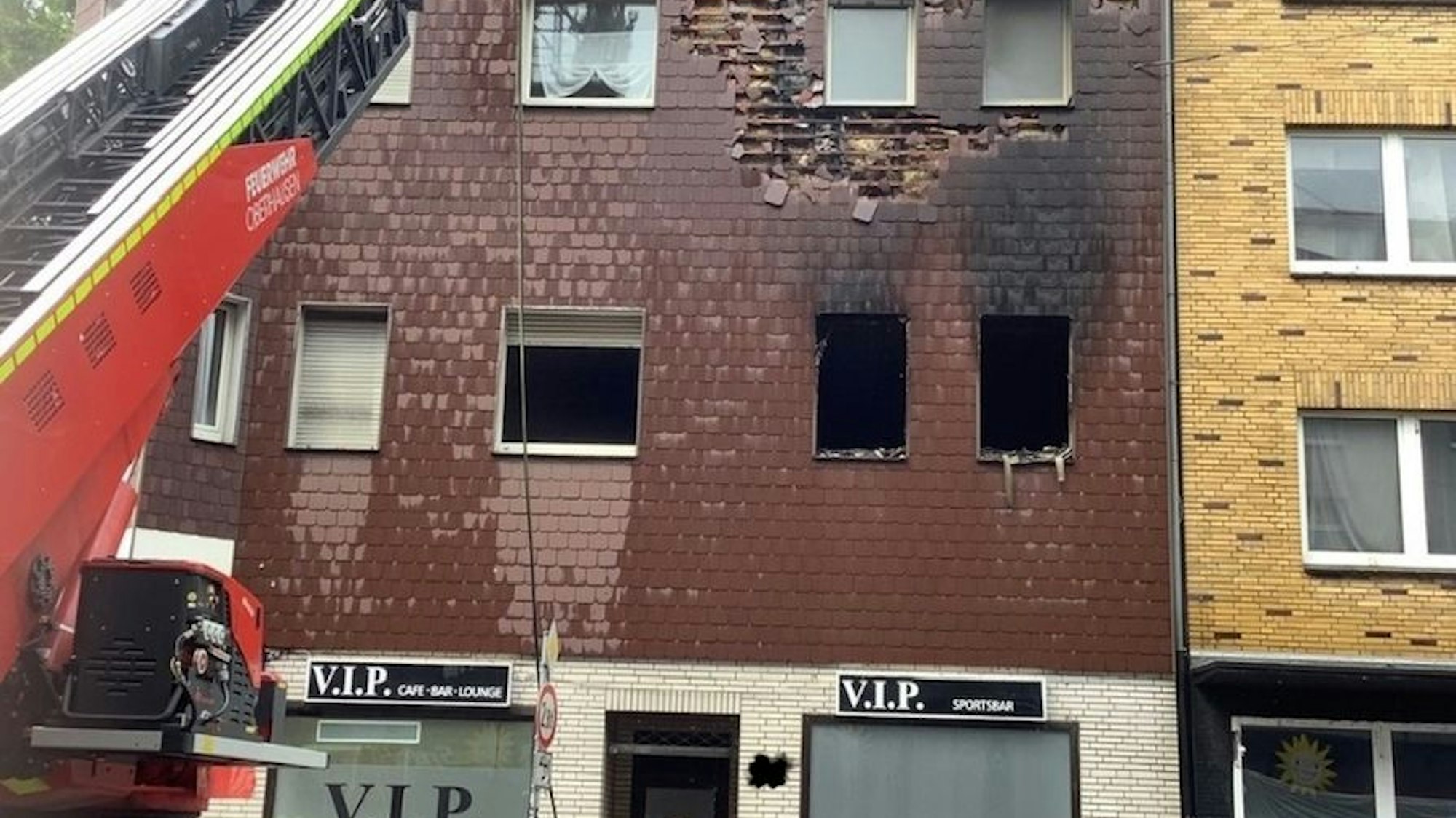Ein Feuerwehrmann löscht einen Brand an einer Fassade.