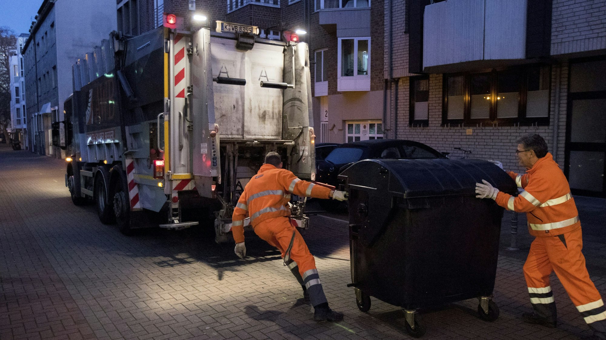 Das Bild zeigt Müllmänner bei der Arbeit.
