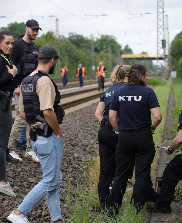 Mitarbeiter der Spurensicherung und der KTU (Kriminaltechnische Untersuchung) stehen in der Nähe der Bahngleise.