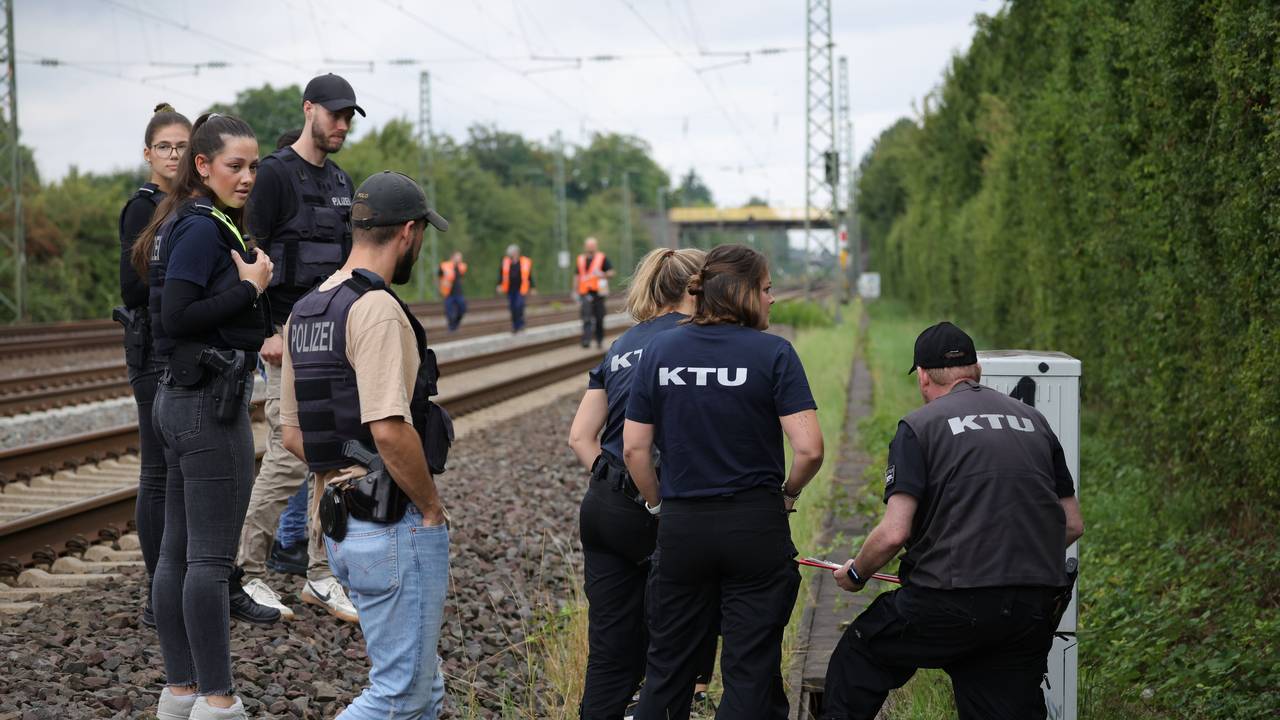 Mitarbeiter der Spurensicherung und der KTU (Kriminaltechnische Untersuchung) stehen in der Nähe der Bahngleise.
