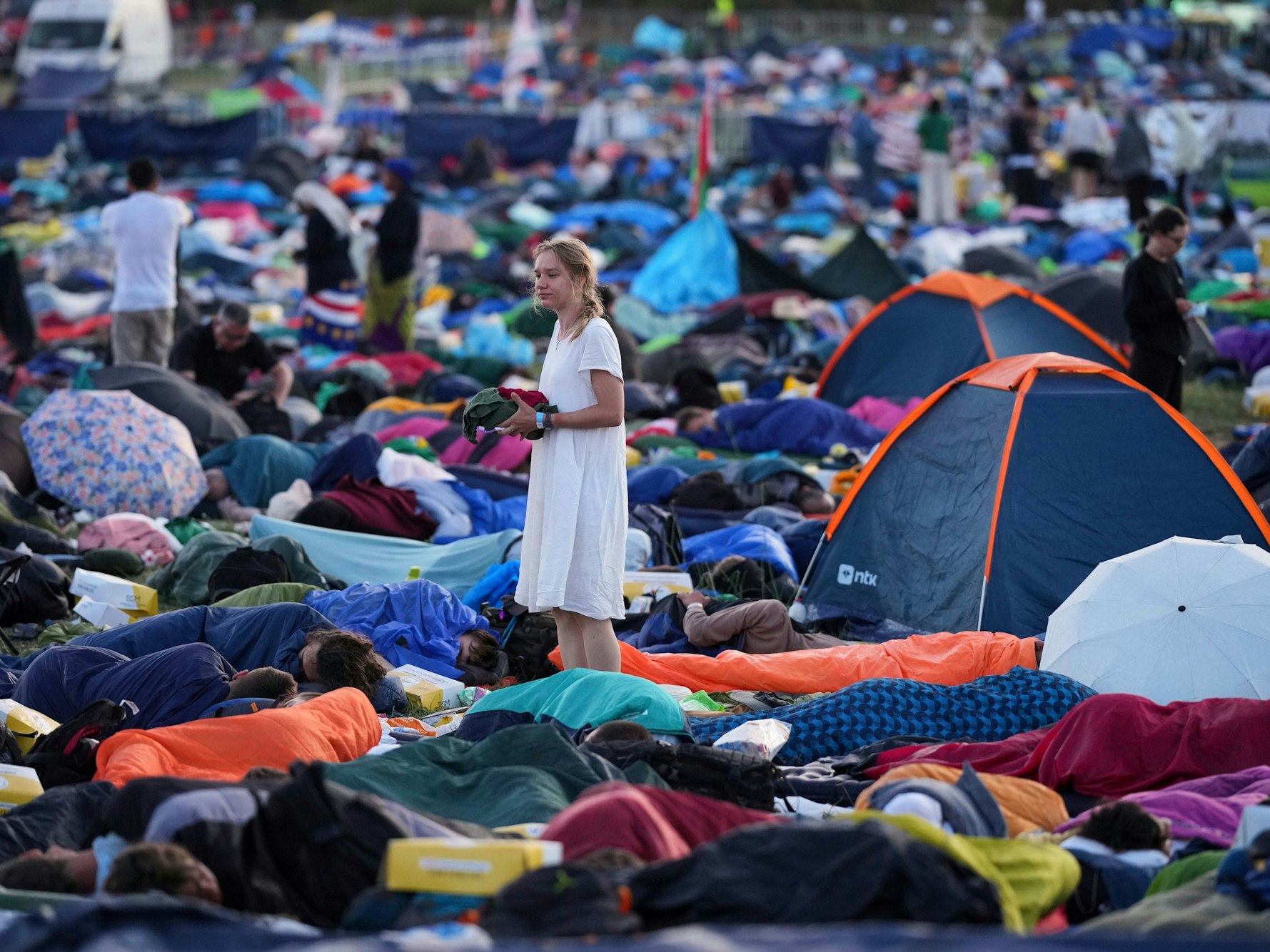 Junge Menschen wachen nach einer Übernachtung auf dem Feld Tor Vergata auf, wo sie am Jugendjubiläum teilnehmen.