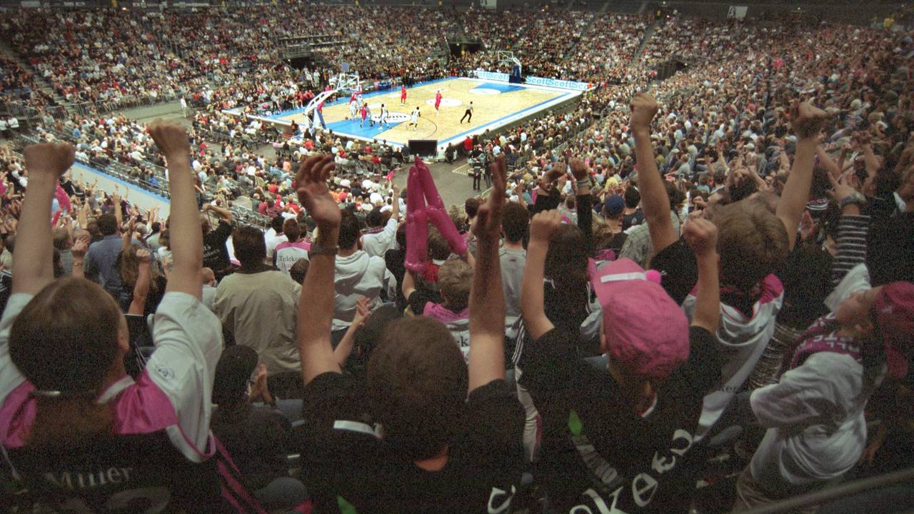 Fans jubeln bei einem Basketball-Spiel.