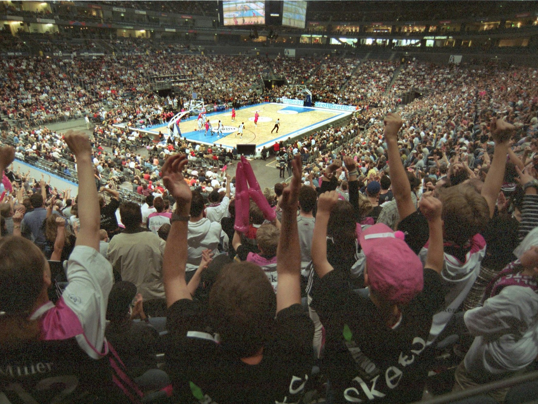 Fans jubeln bei einem Basketball-Spiel.