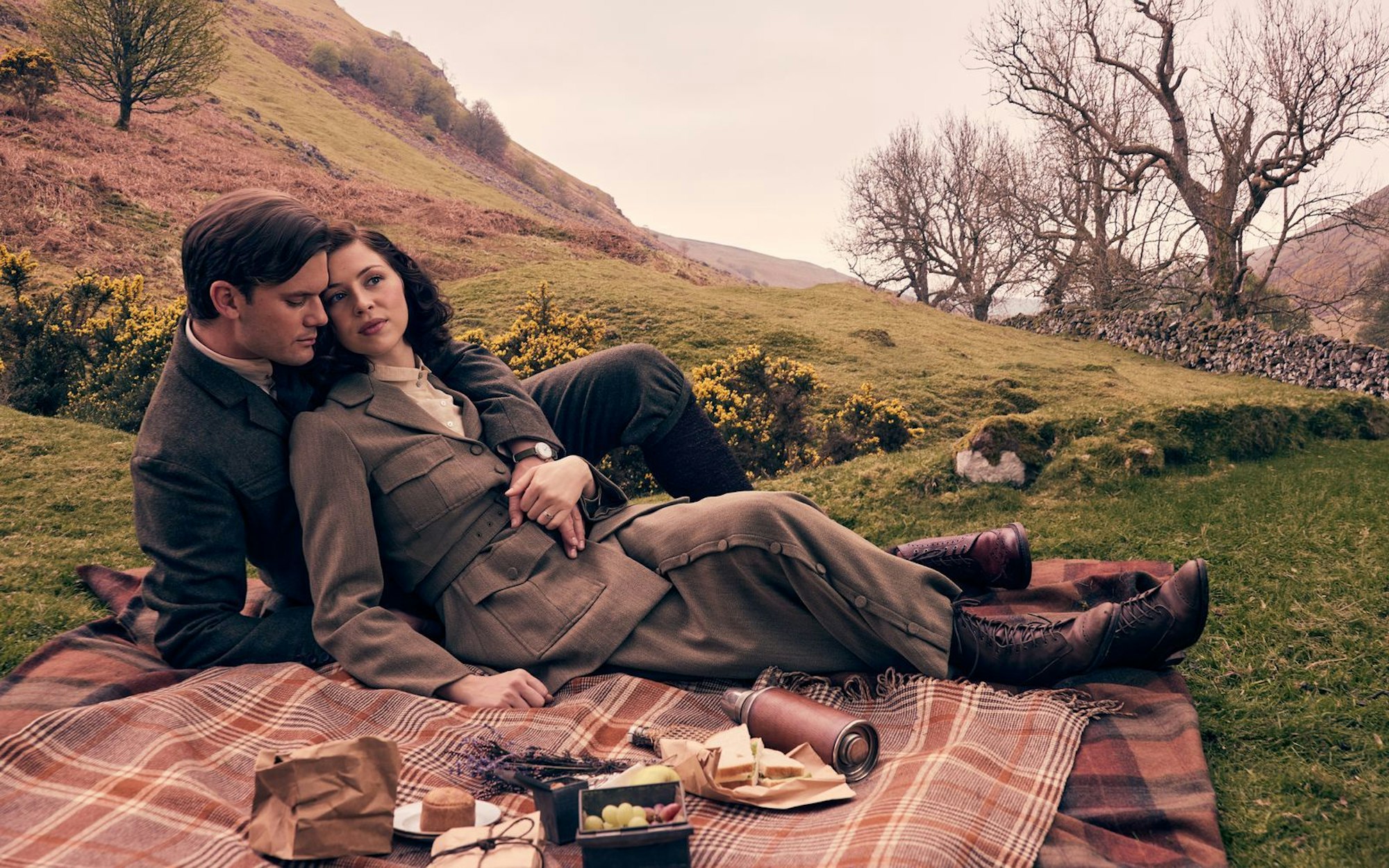 Die traumhafte Landschaft der schottischen Highlands spielt auch in „Outlander: Blood Of My Blood“ die heimliche Hauptrolle. Vor den grünen Hügeln erzählt das Prequel unter anderem, wie sich Henry Beauchamp (Jeremy Irvine) und Julia Moriston (Hermione Corfield) einst kennengelernt haben. (Bild: Sony Pictures Connect Inc./2024 Starz Entertainment, LLC/Sanne Gault)