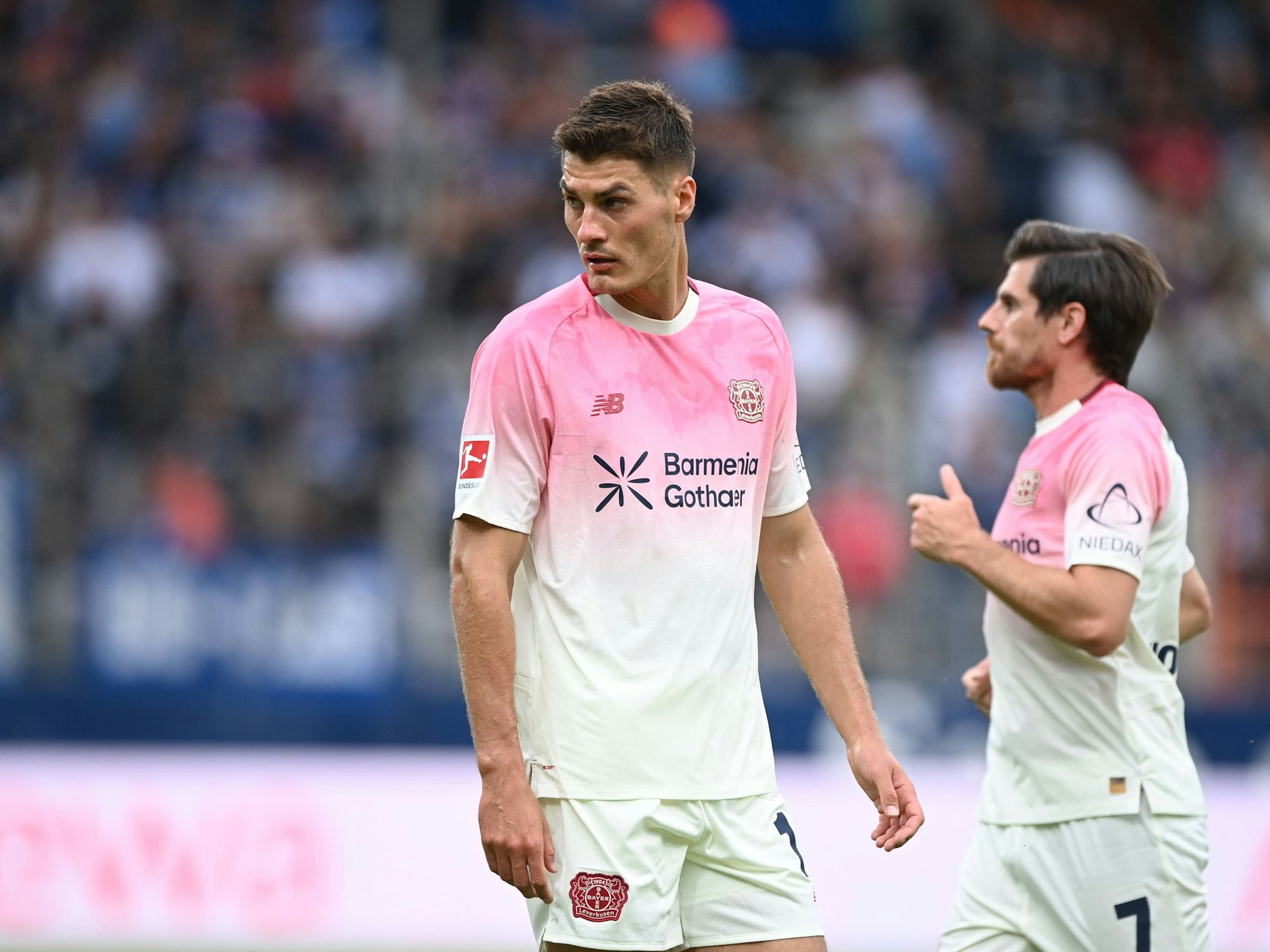 Patrik Schick steht im Vordergrun, hinter ihm läuft Jonas Hofmann.