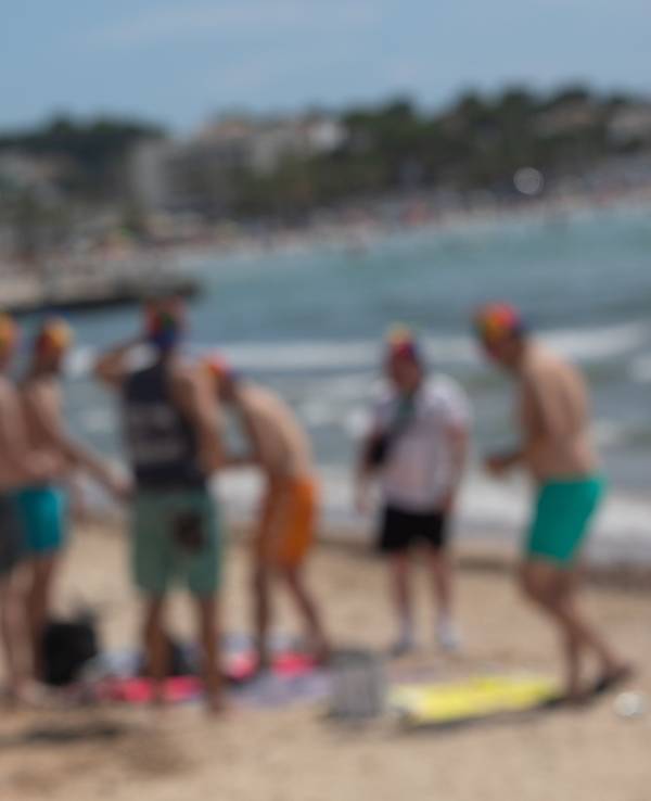Alkoholflaschen neben den Sonnenbadenden am Strand von Arenal auf Mallorca.