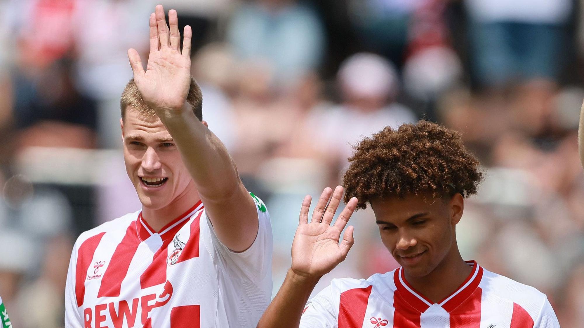 Steffen Tigges und Neo Telle winken bei einem FC-Spiel ins Publikum.