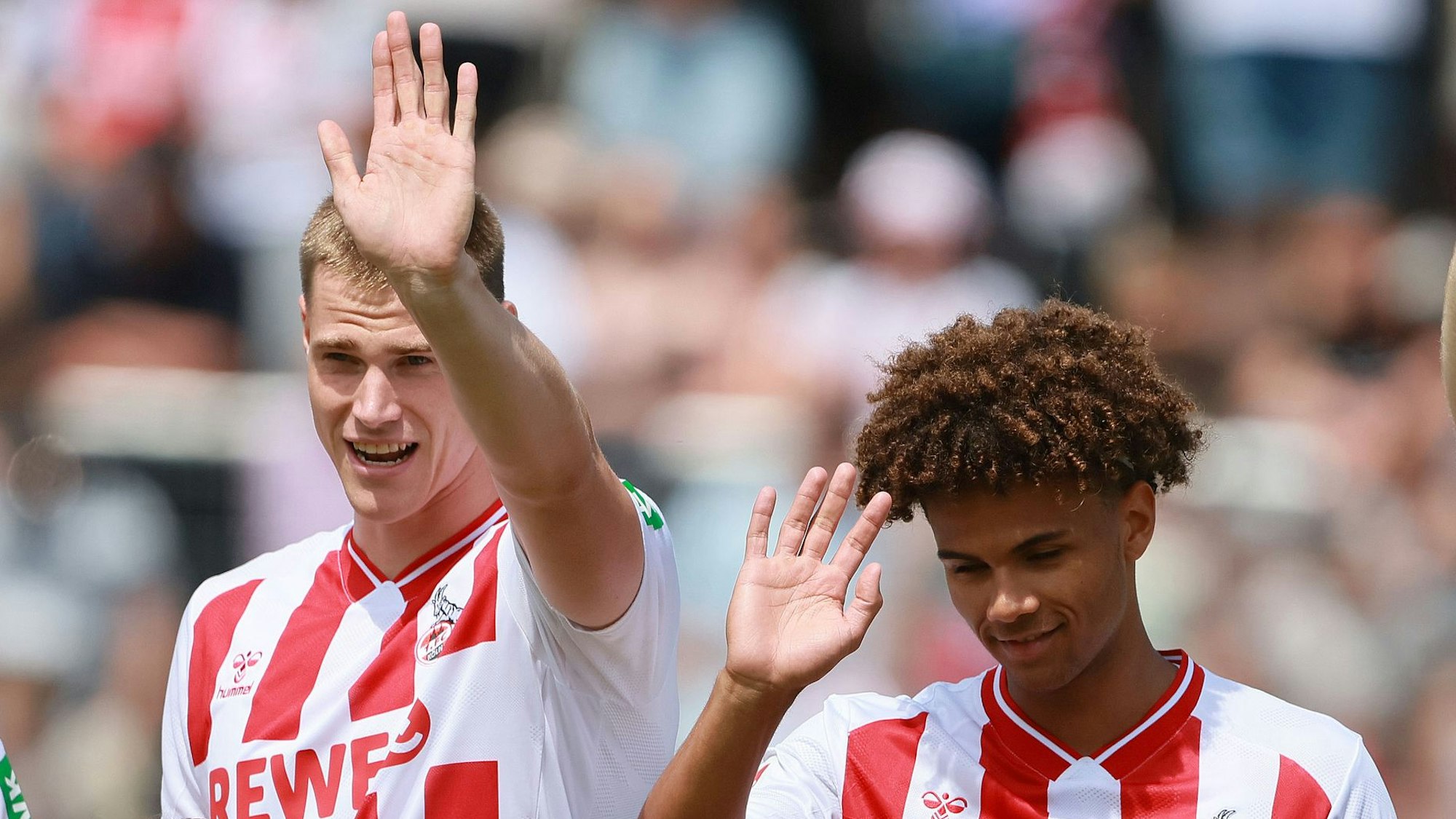 Steffen Tigges und Neo Telle winken bei einem FC-Spiel ins Publikum.