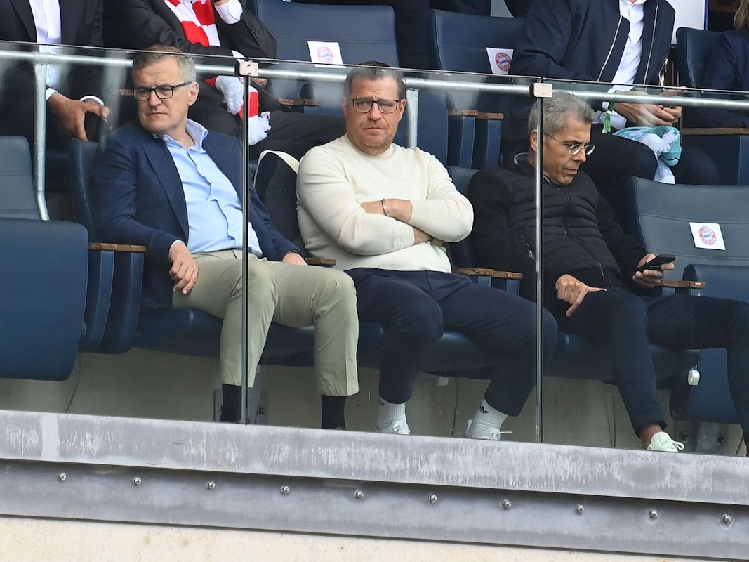 Jan-Christian Dreesen, Max Eberl und Michael Diederich sitzen nebeneinander auf der Tribüne
