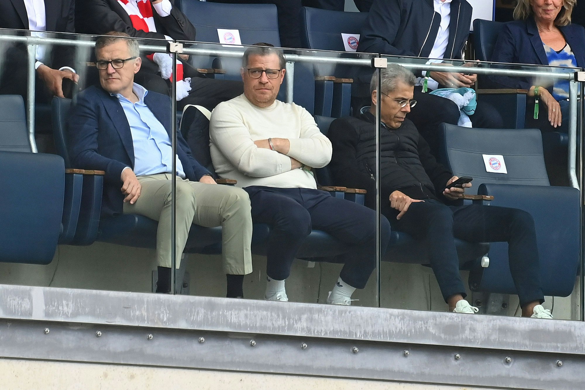 Jan-Christian Dreesen, Max Eberl und Michael Diederich sitzen nebeneinander auf der Tribüne