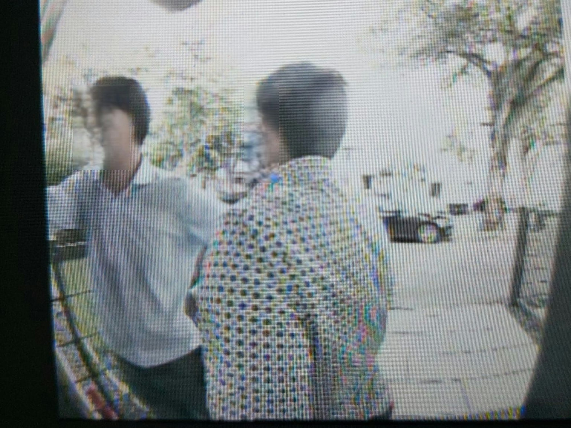 Zwei Männer stehen vor einer Haustür, einer klingelt.