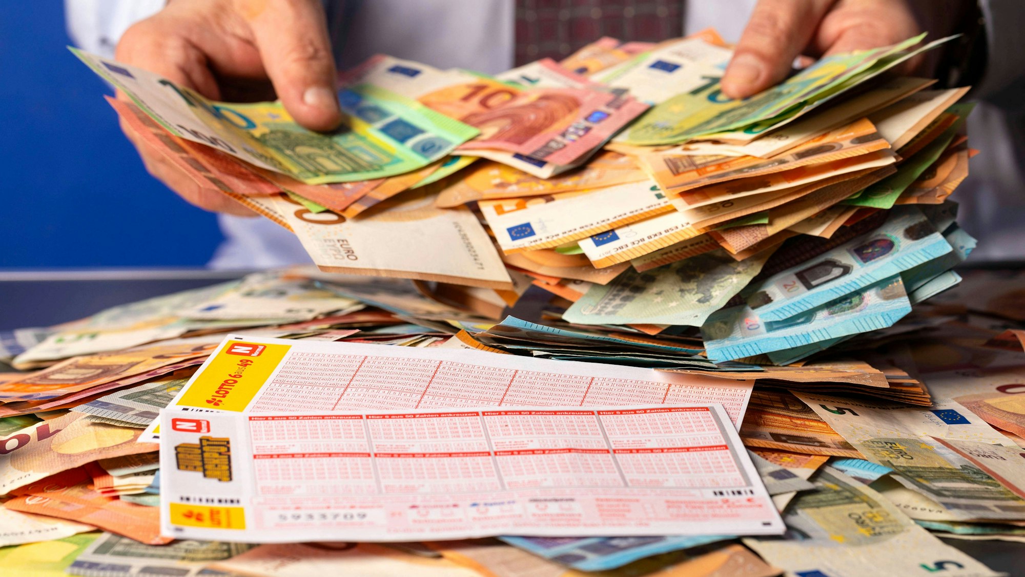 Eurojackpot-Lottoschein mit Kugelschreiber und bunten Euro-Banknoten