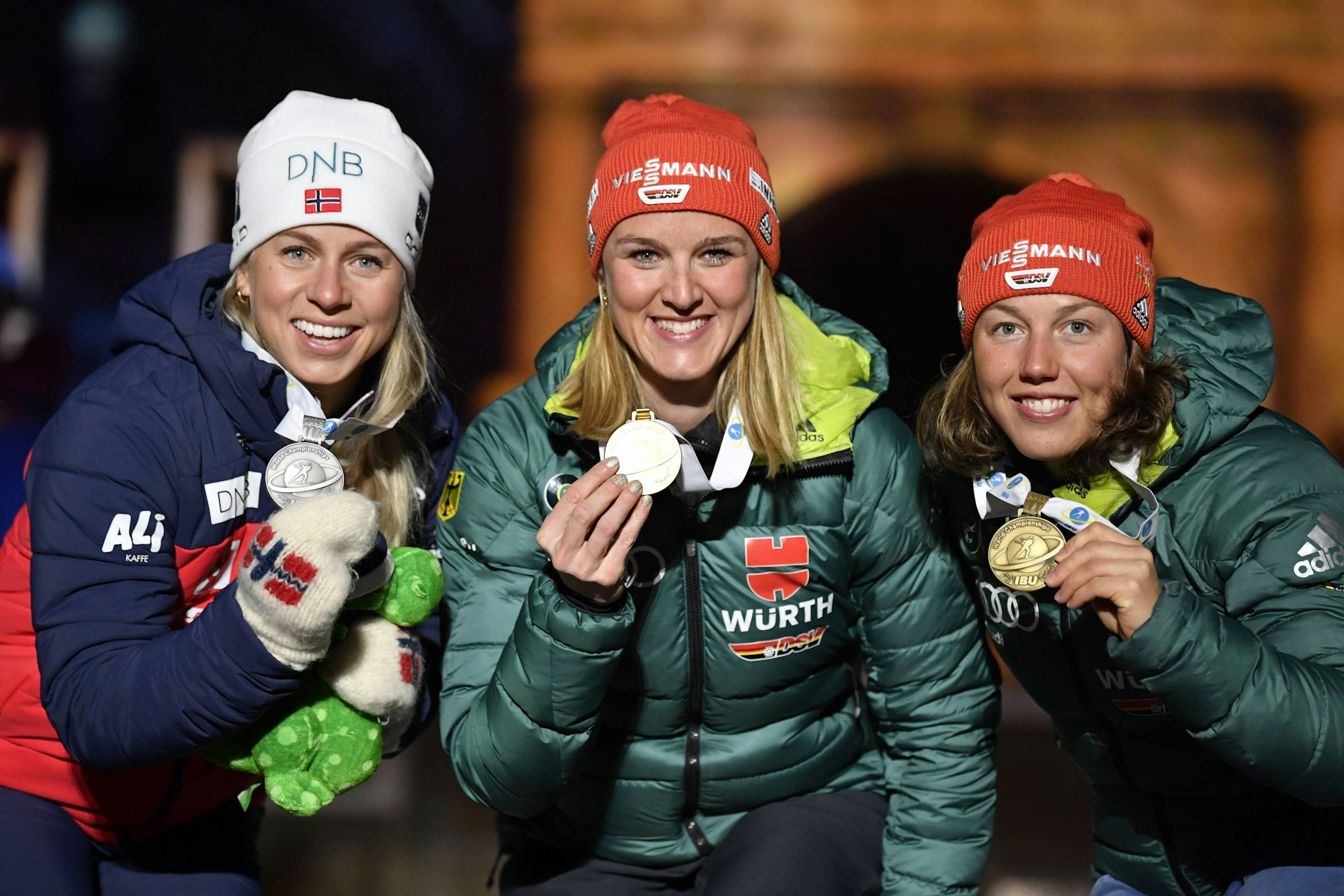 Tirill Eckhoff, Denise Hermann-Wick und Laura Dahlmeier posieren gemeinsam mit ihren gewonnen Medaillen.