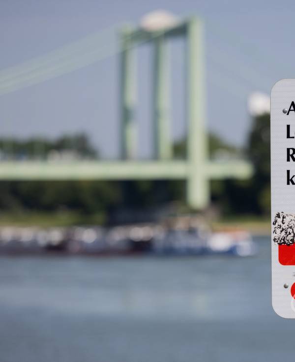 Ein Hinweisschild mit der Aufschrift „Achtung Lebensgefahr“ weist am Rhein in Rodenkirchen auf die Gefahren beim Schwimmen in dem Fluss hin.