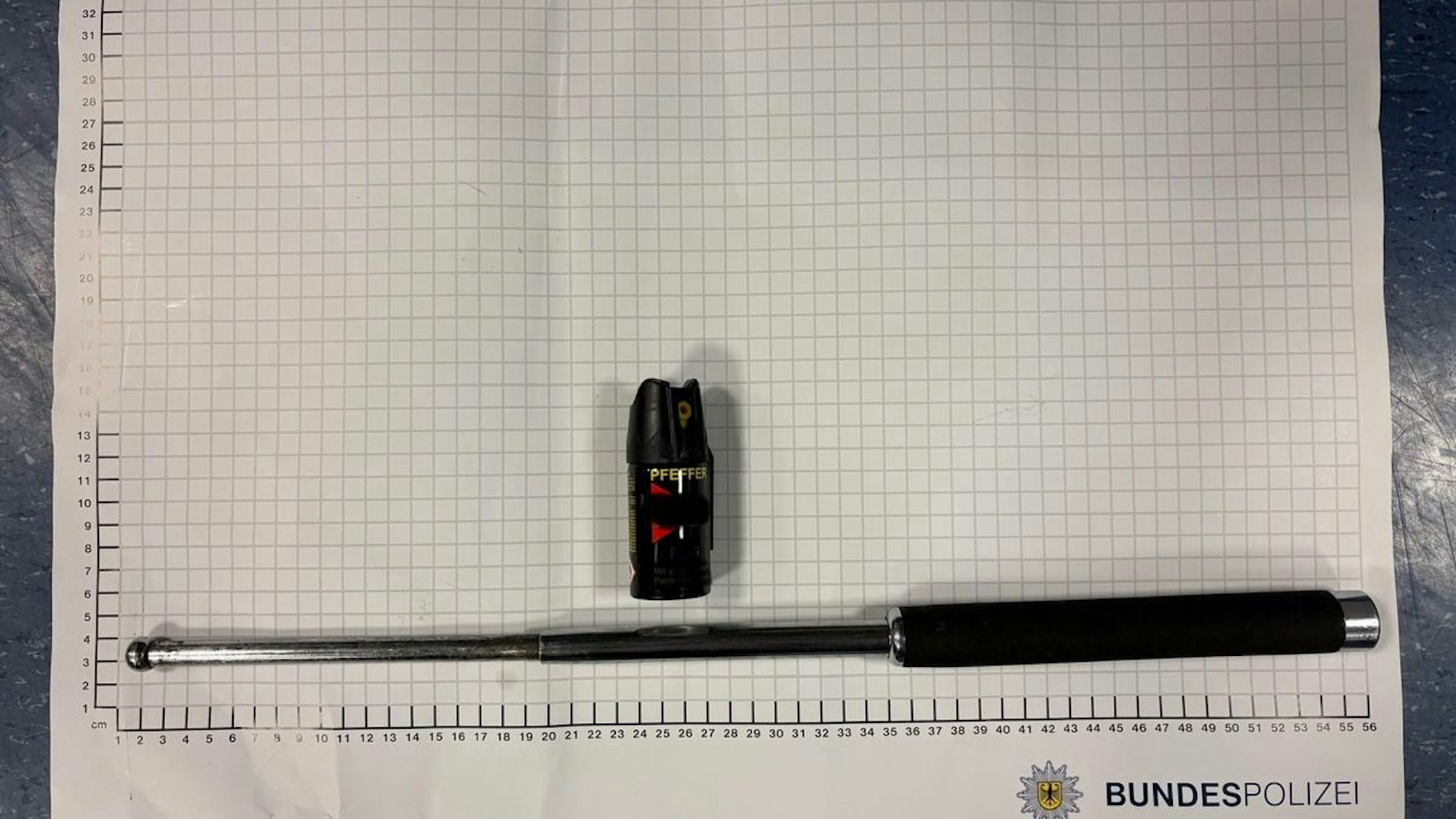 Ein Schlagstock und Pfefferspray liegen auf einem Tisch.