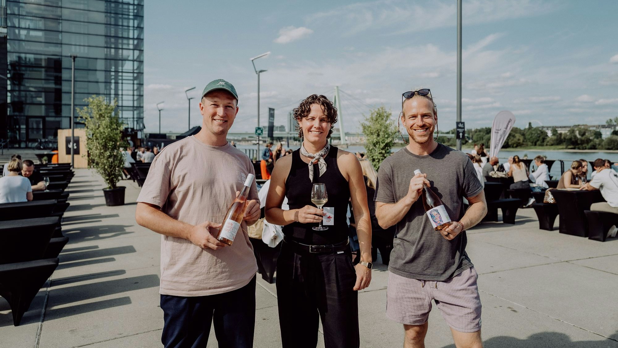 Heiko Falk, Silja Mende-Kamps und Ole Ullenboom mit Weinflasche in der Hand.
