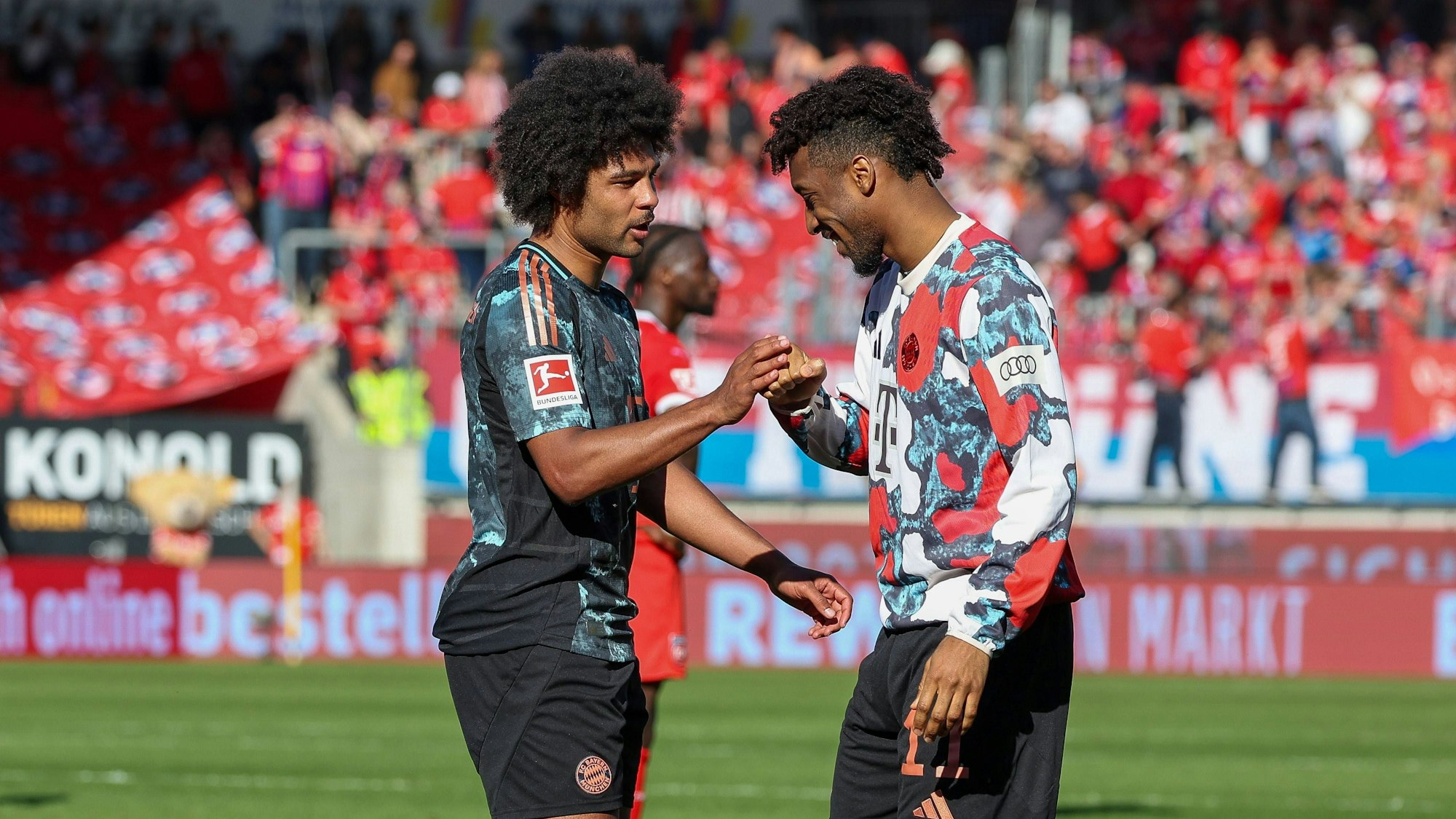 Serge Gnabry und Kingsley Coman (r.) klatschen sich ab.