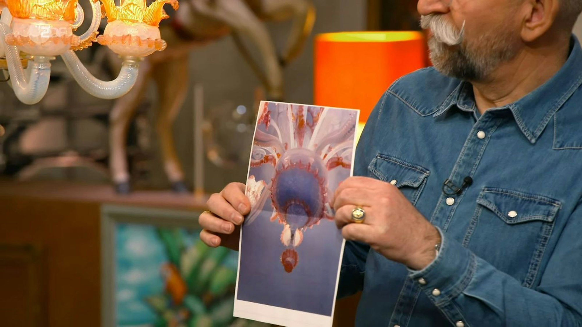 Ein Mann hält ein Bild eines Leuchters in der Hand.
