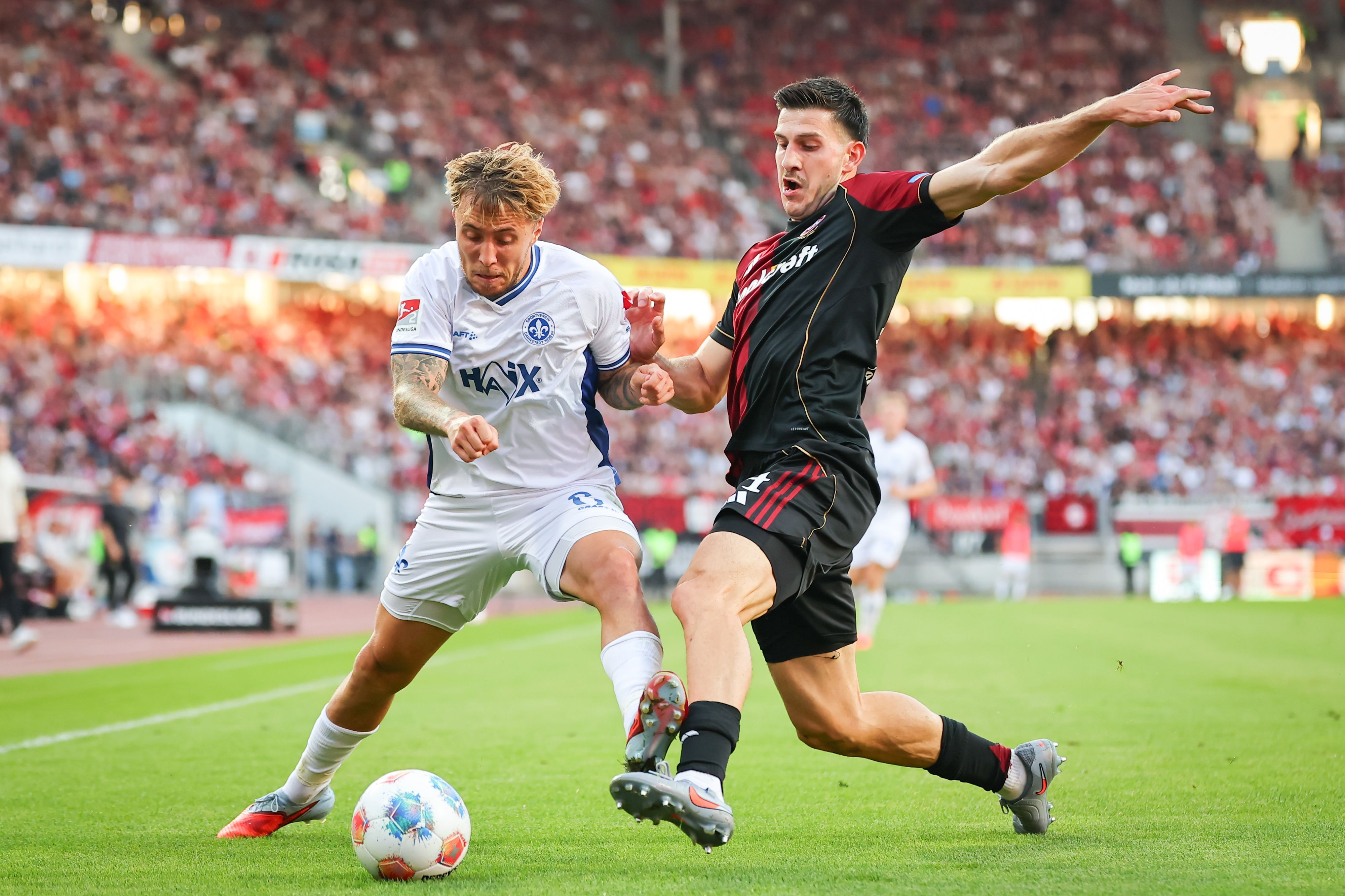 Luka Lochoshvili (1. FC Nürnberg, r) und Luca Marseiler (SV Darmstadt 98) kämpfen um den Ball.