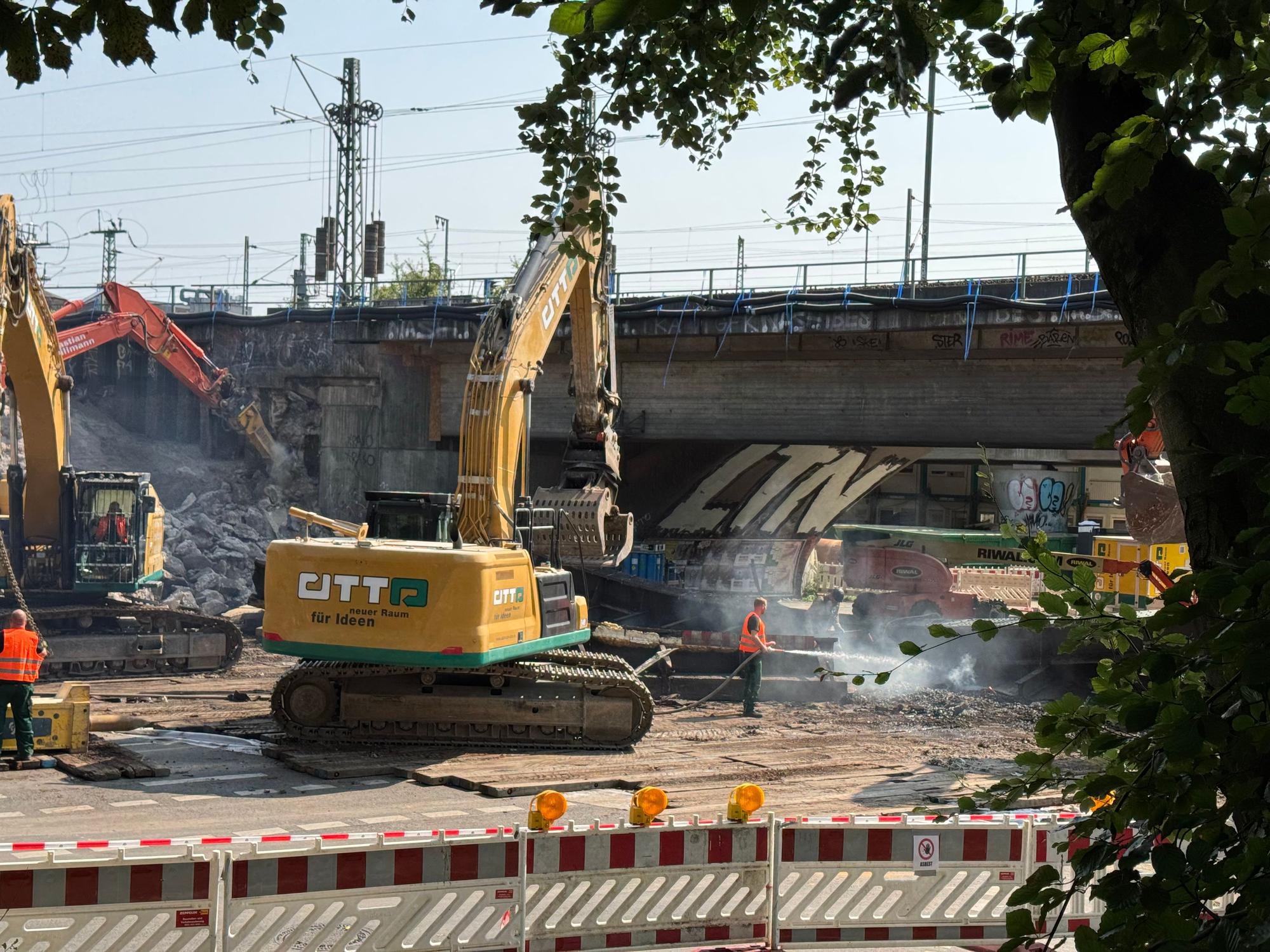Zwei Bagger stehen an einer Brücke.
