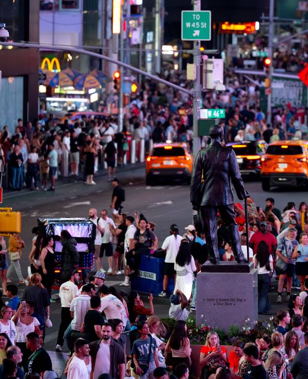 Zahlreiche Menschen stehen am frühen Abend in Manhattan am Times Square.