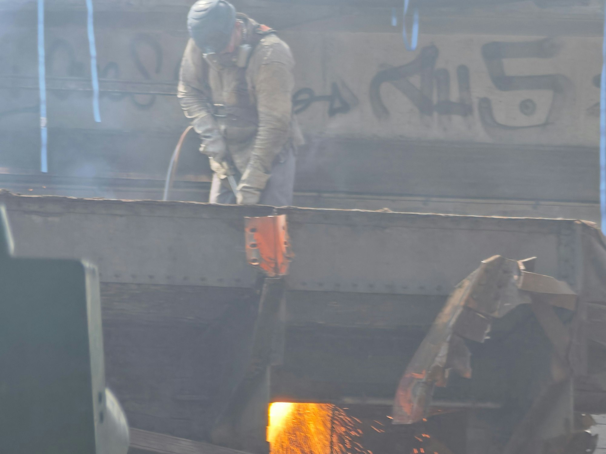 Ein Mann schweißt einen Stahlträger auseinander.