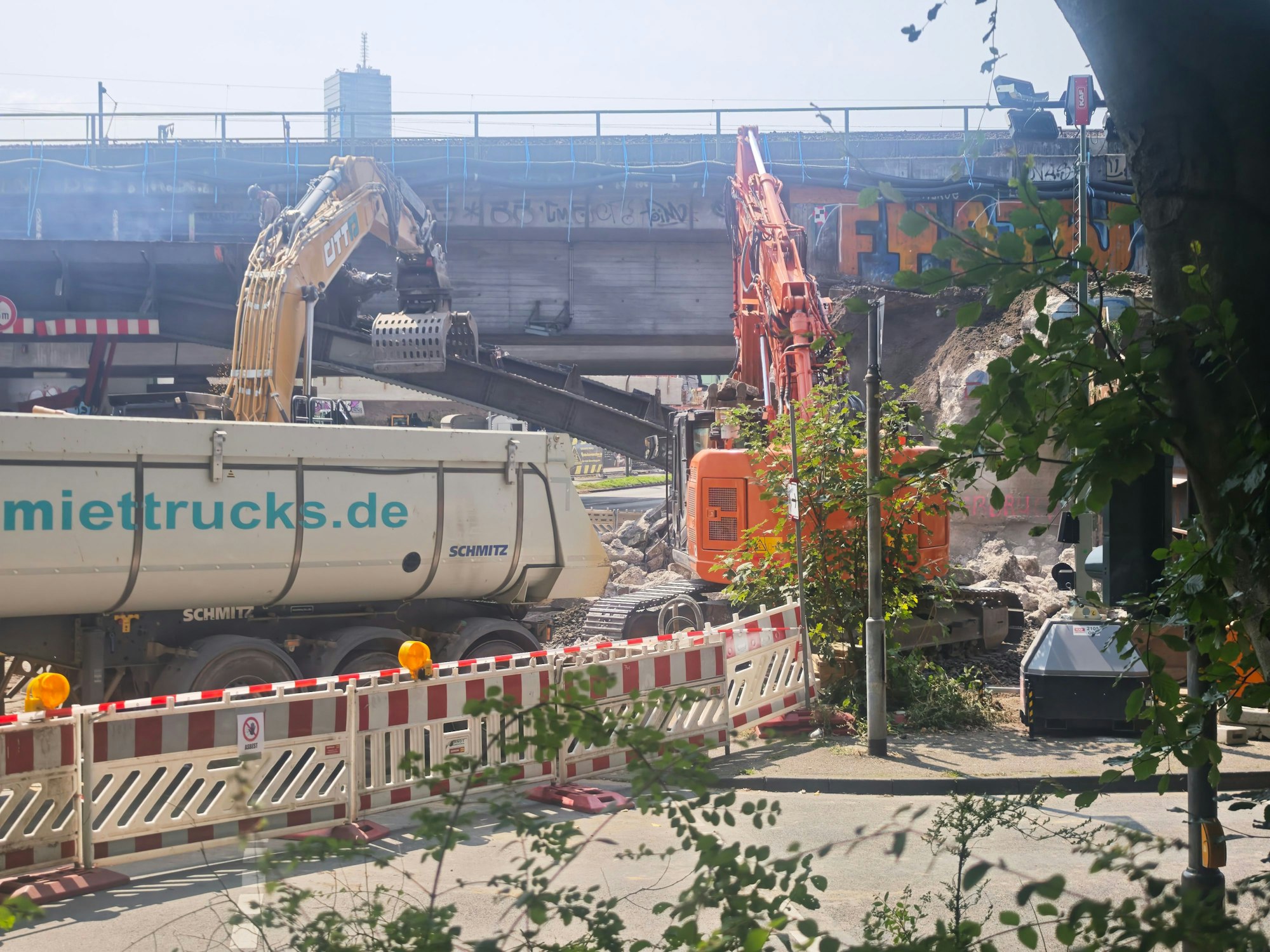 Ein Bagger trägt einen Stahlträger weg.