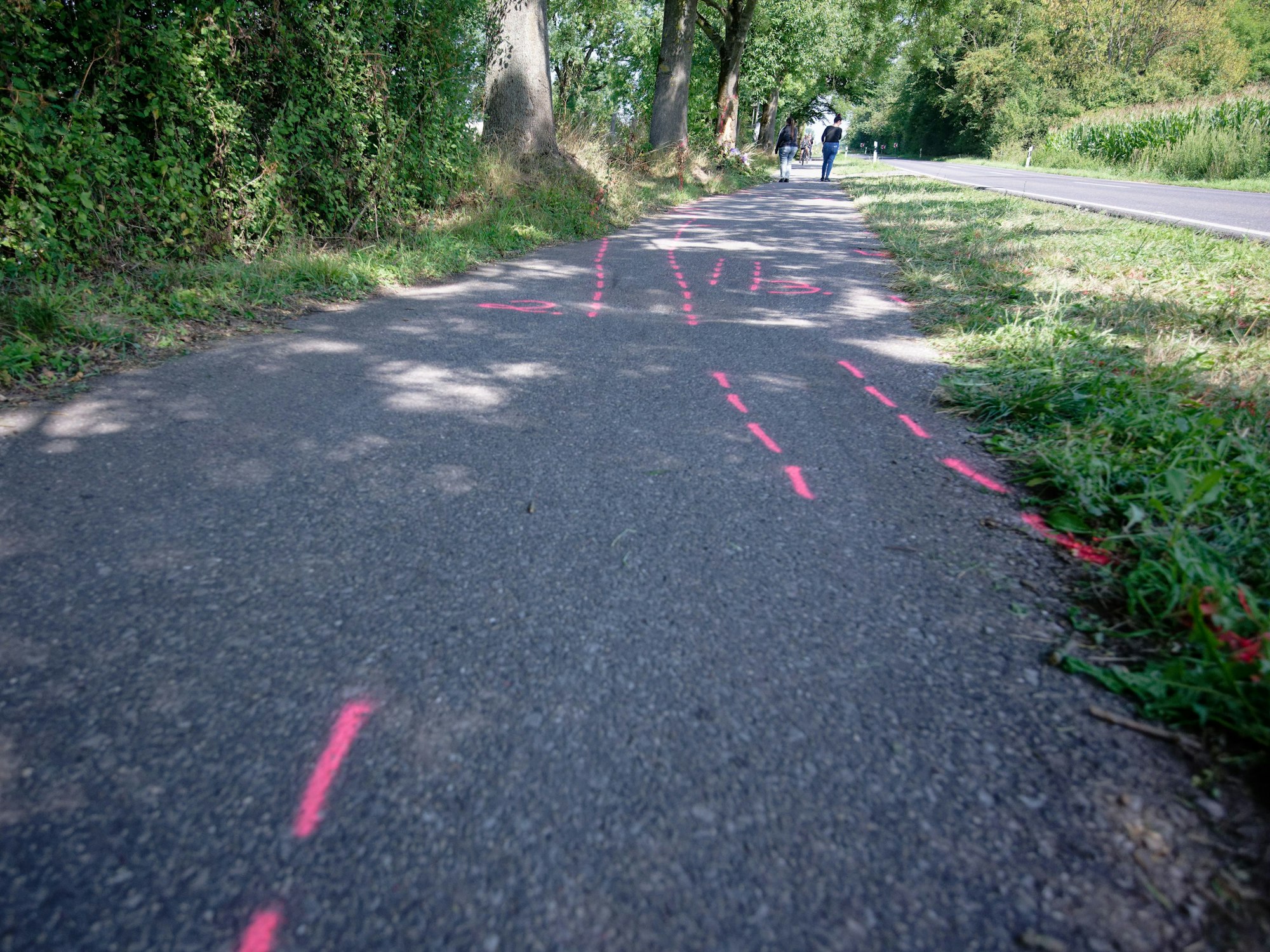 Auf einem Gehweg befinden sich Markierungen.