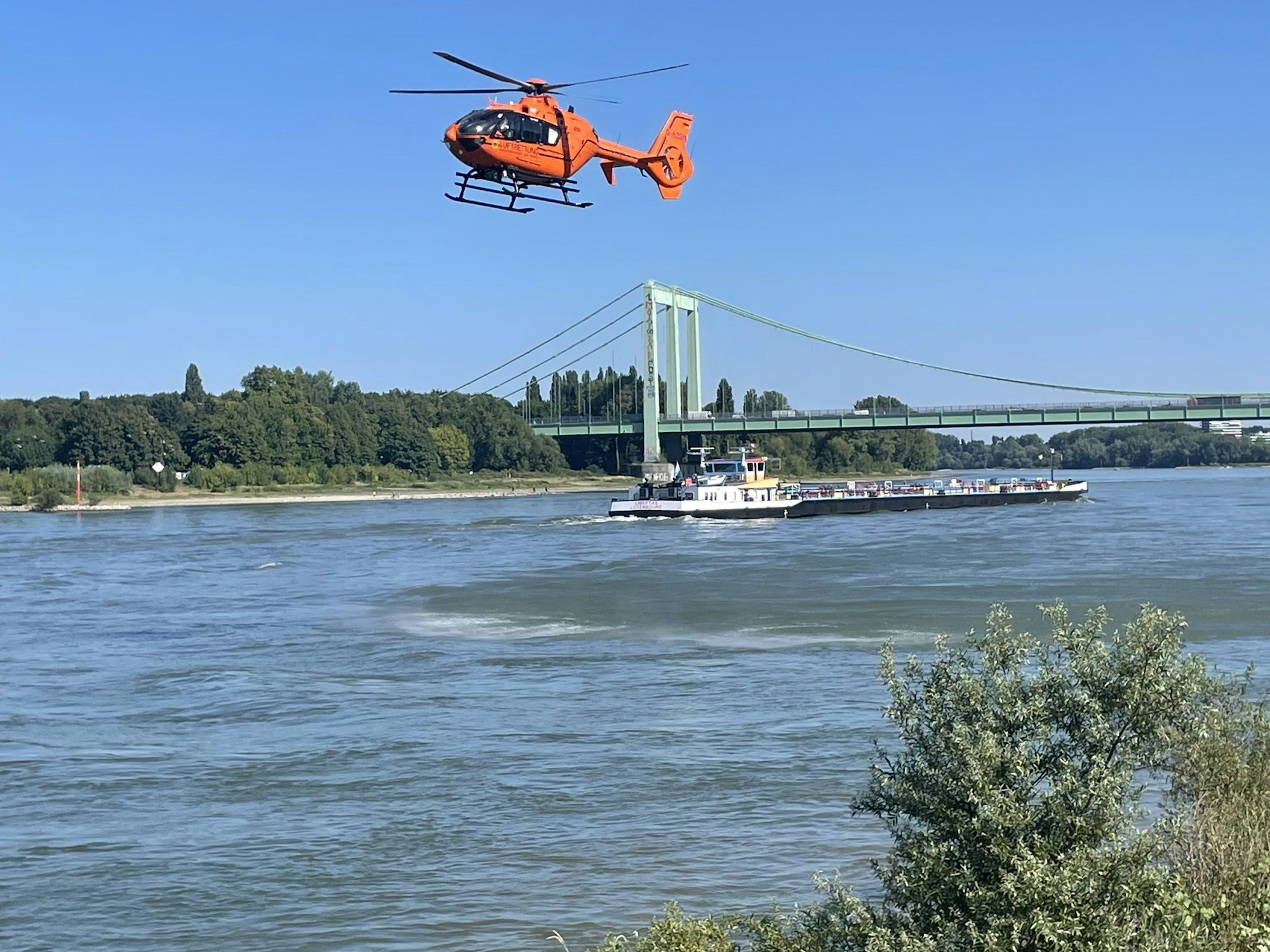 Ein Hubschrauber fliegt über dem Rhein.